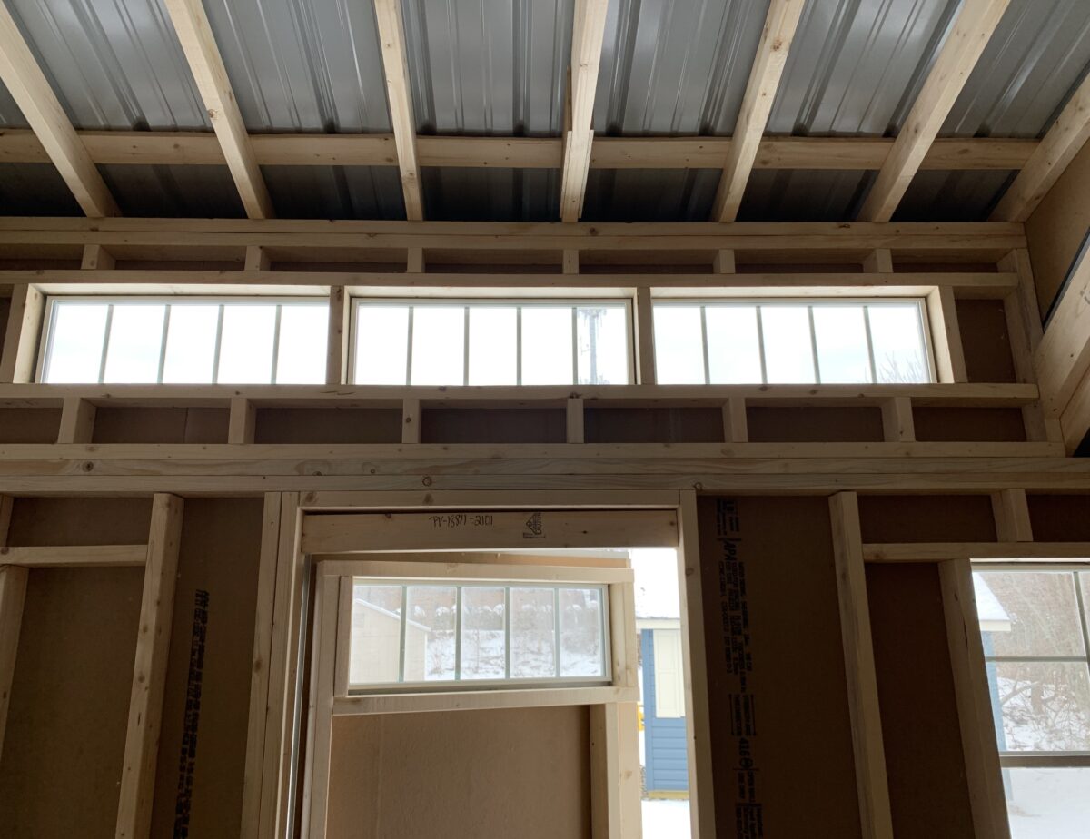 3-foot single entry door with transom windows and a diamond kick plate on a grey shed.