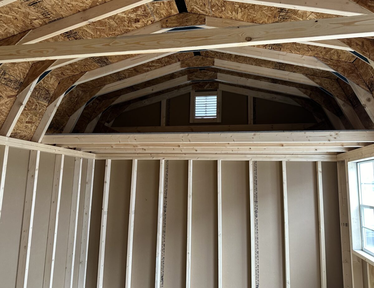 Interior of a 12x16 shed showing a 4x12 storage loft and wood framing.