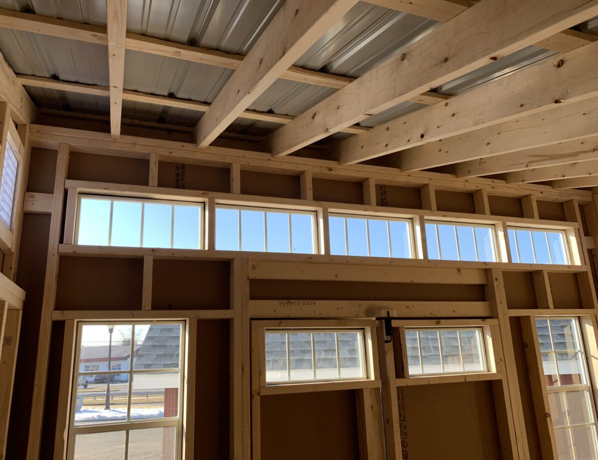 Interior of a 10x12 studio shed showing clean wood framing and natural lighting.