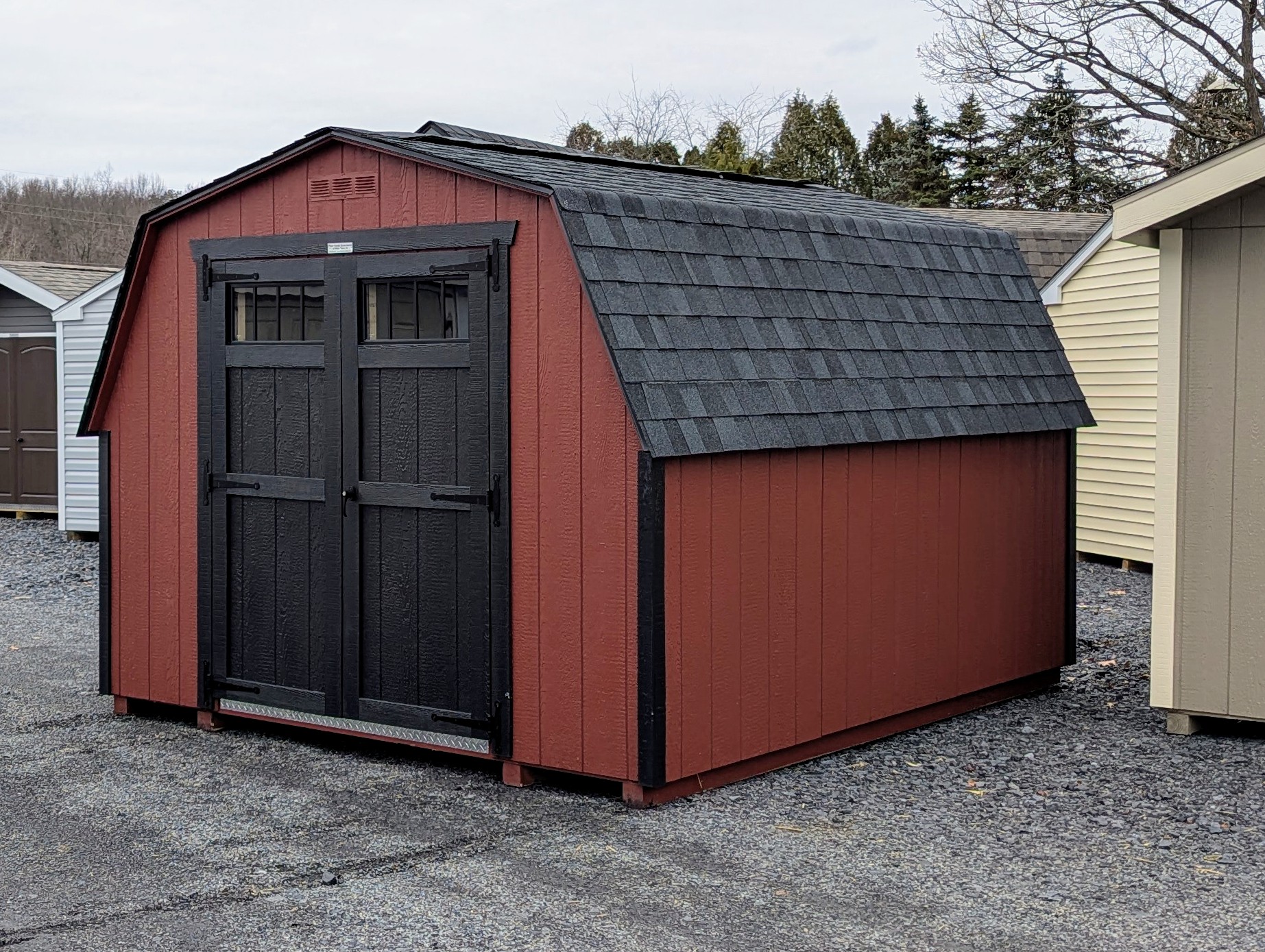10x12 Madison Series Mini Barn shed painted red with black trim, and black door with transom windows