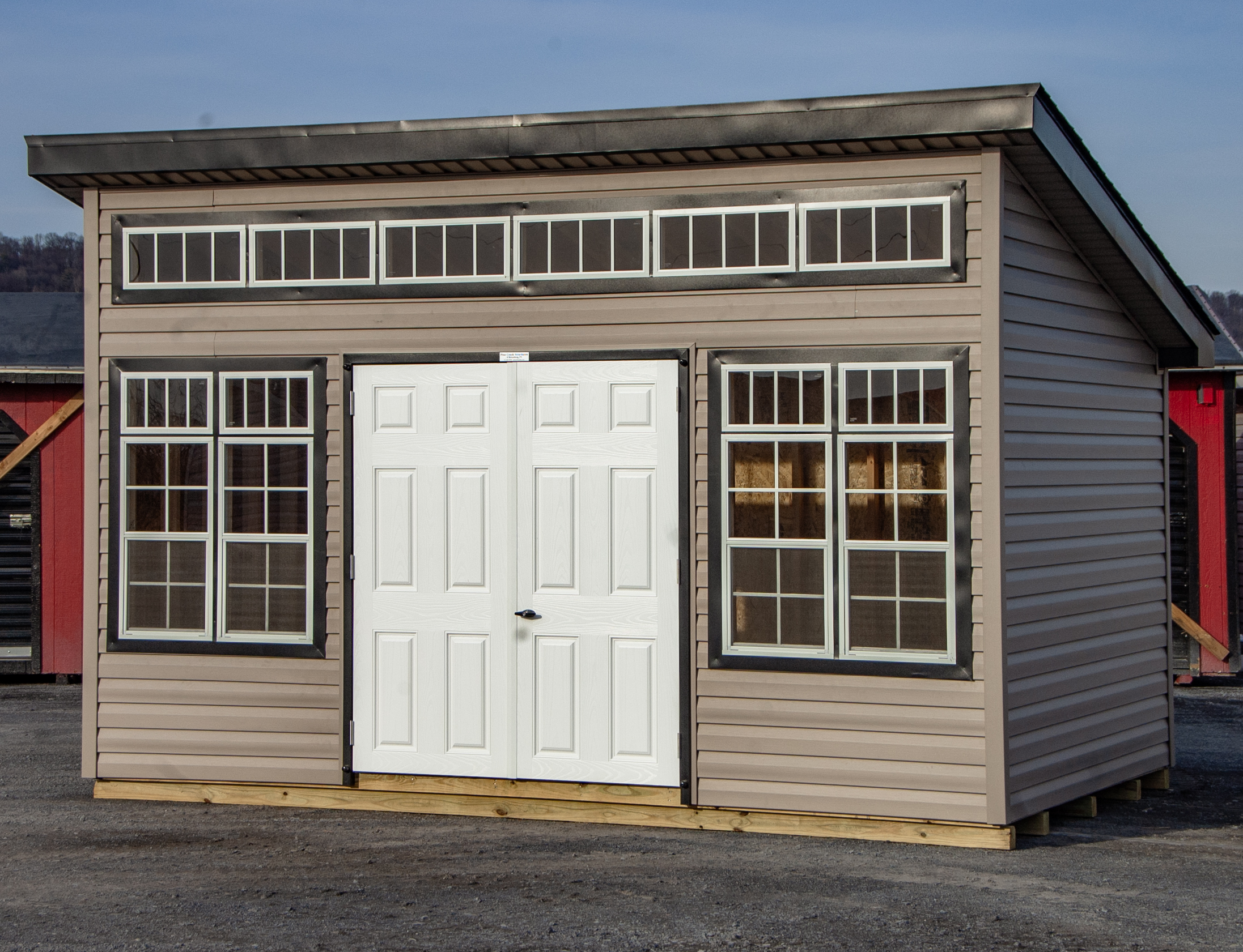 10x14 Studio Style Storage Shed with many windows and Pebble Clay vinyl siding