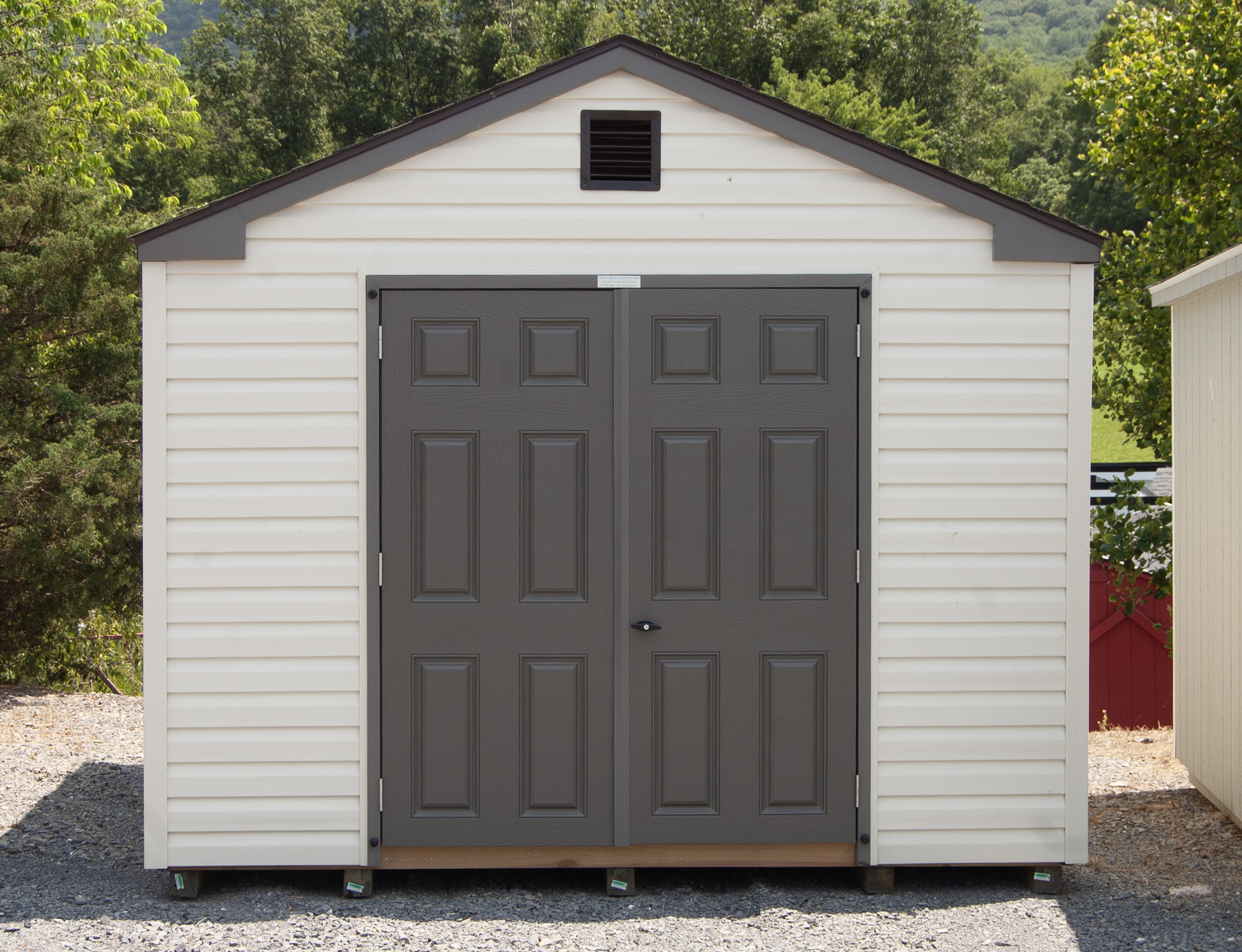 10x12 Madison Series (Economy Line) Storage Shed with peak roofline, vinyl siding, and fiberglass double doors
