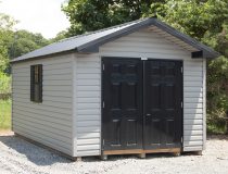 10×16 Front Entry Peak Storage Shed with grey vinyl siding, black fiberglass doors, and black metal roof