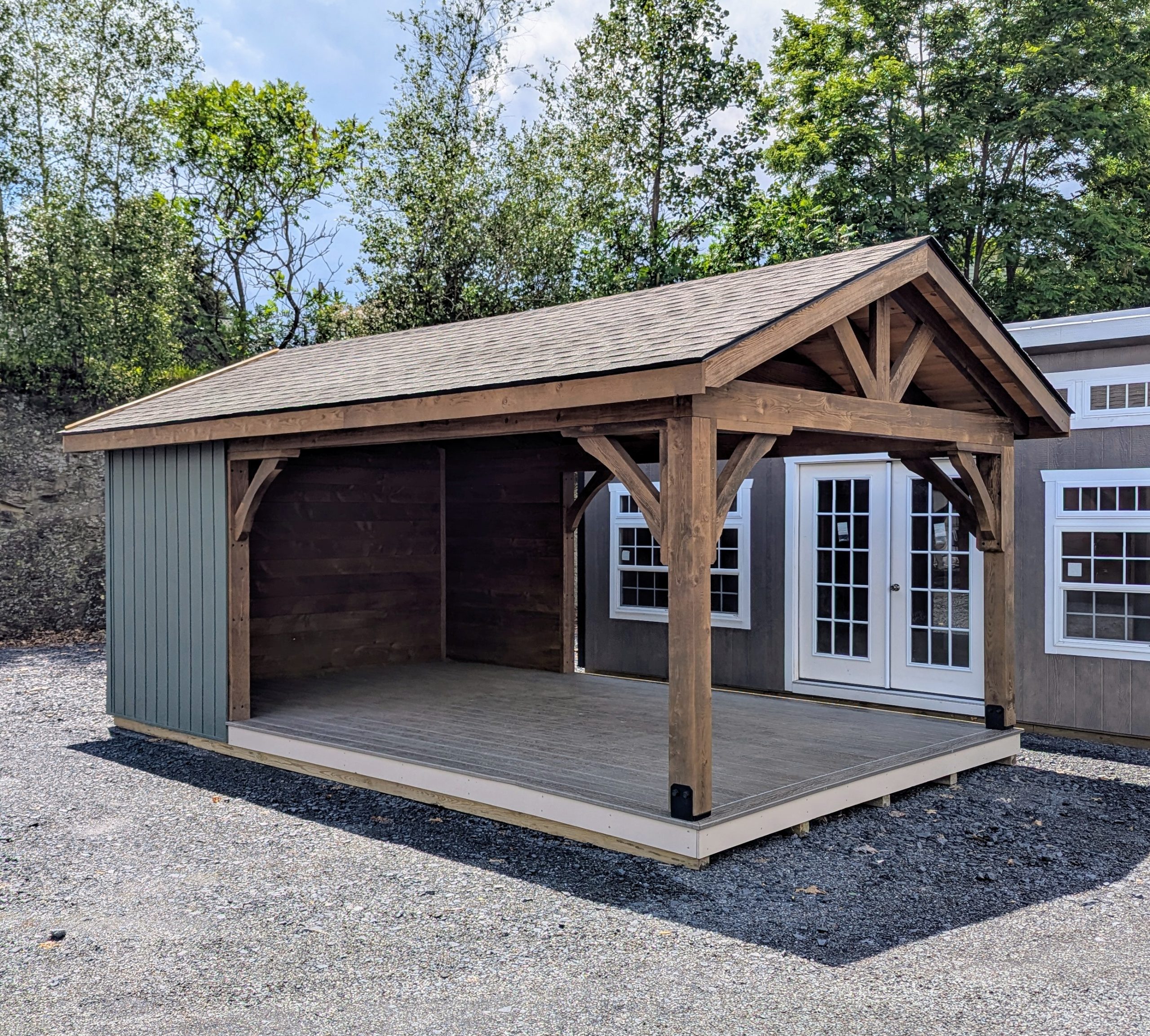 12x20 cabana with six foot, three sided enclosure. Appears rustic with its 6x6 rough-cut hemlock posts stained a deep smokey brown. The forest gren vinyl board and batten siding adds to the rustic charm; as does the rough-cut hemlock interior