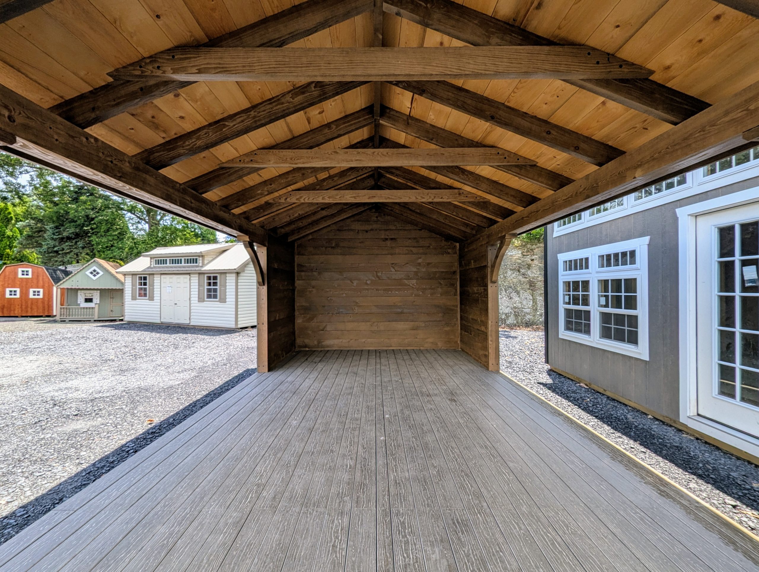 Looking into a 12x20 cabana with six foot, three sided enclosure. Appears rustic with its 6x6 rough-cut hemlock posts stained a deep smokey brown. The rough-cut hemlock interior adds to the rustic charm.