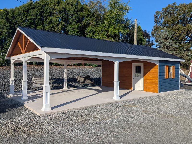 20x26 cabana with a metal roof, white vinyl posts, wooden siding, and two porch swings hanging in the open pavilion area.