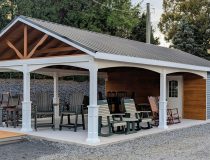 20x26 cabana with metal roof and open pavilion space, furnished with outdoor chairs and tables, attached to an enclosed wooden room with window and shutters.