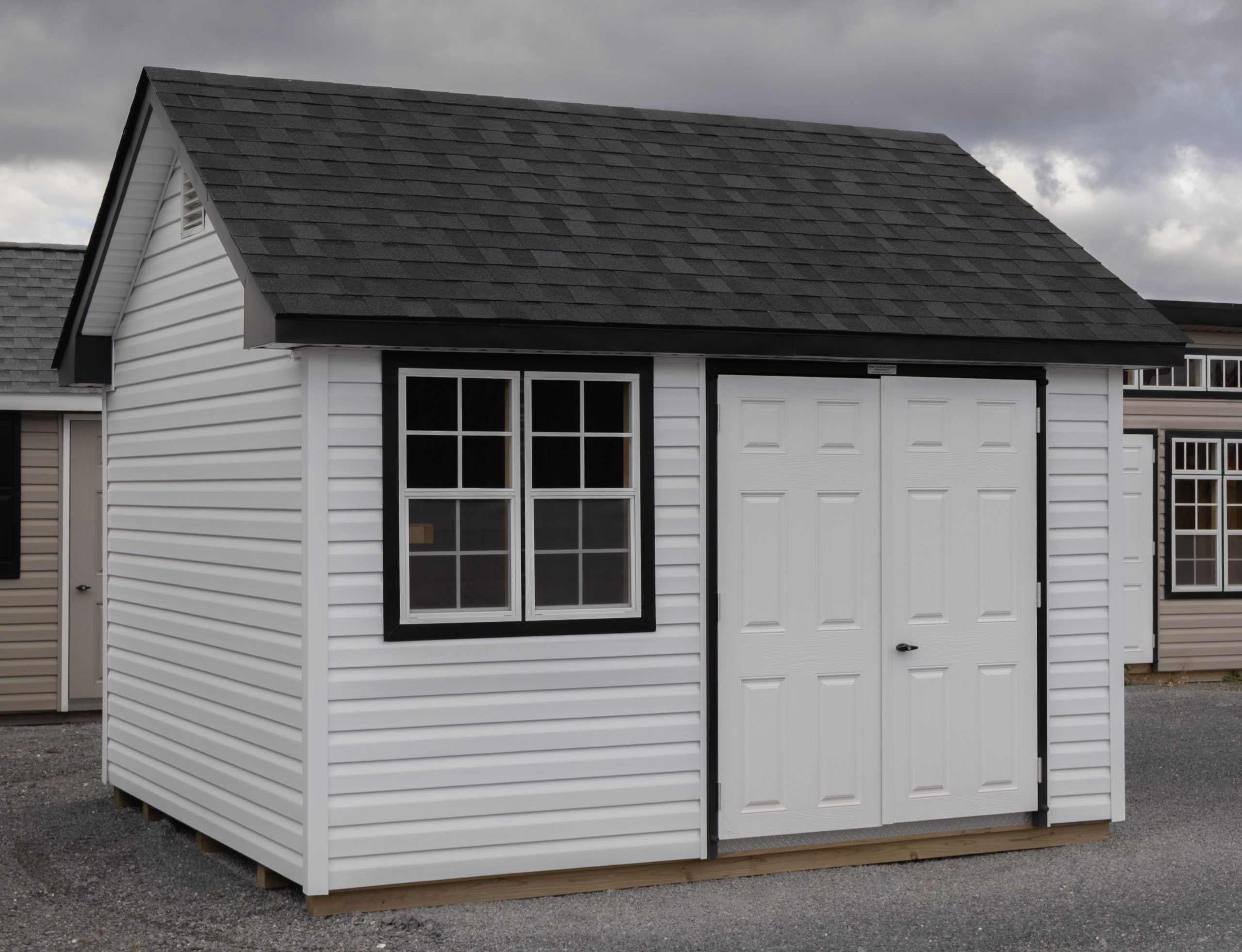 10x12 Premium Cape Cod Style Storage Shed with vinyl siding and custom shelf built inside