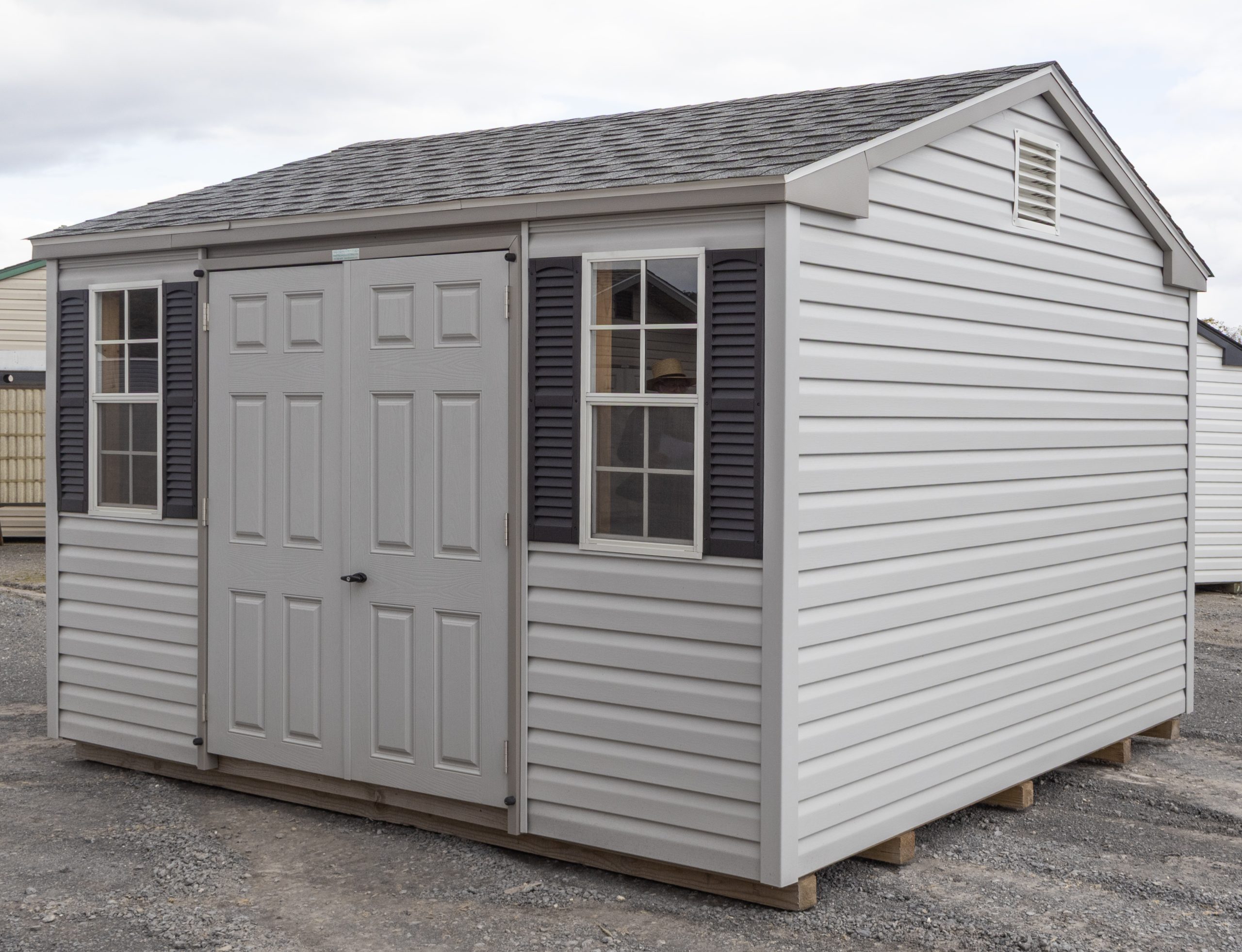 10x12 Peak Style Storage Shed With grey vinyl siding, double doors, two windows, and gable end vents