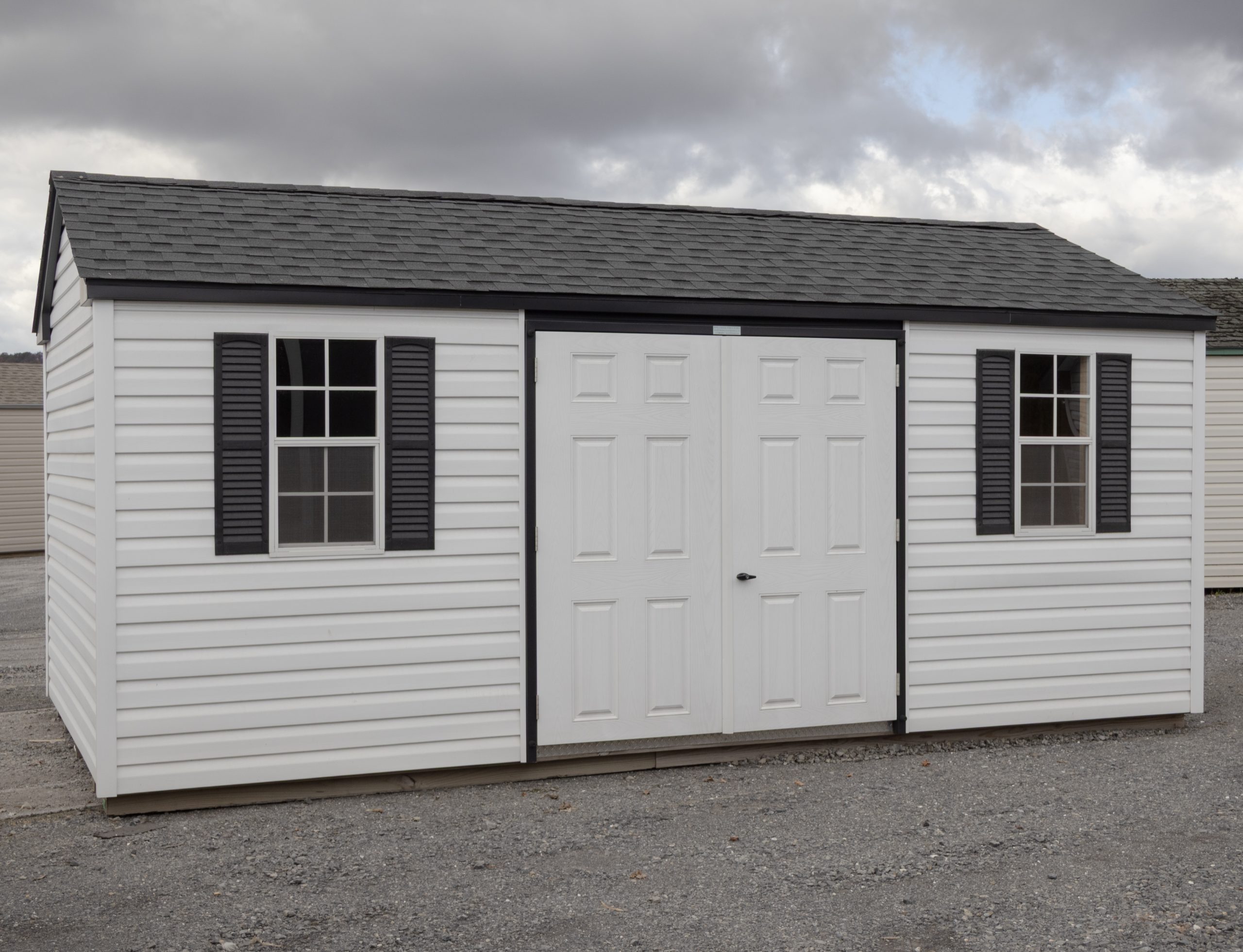 10x18 Peak Style Storage Shed with white vinyl siding and black accents