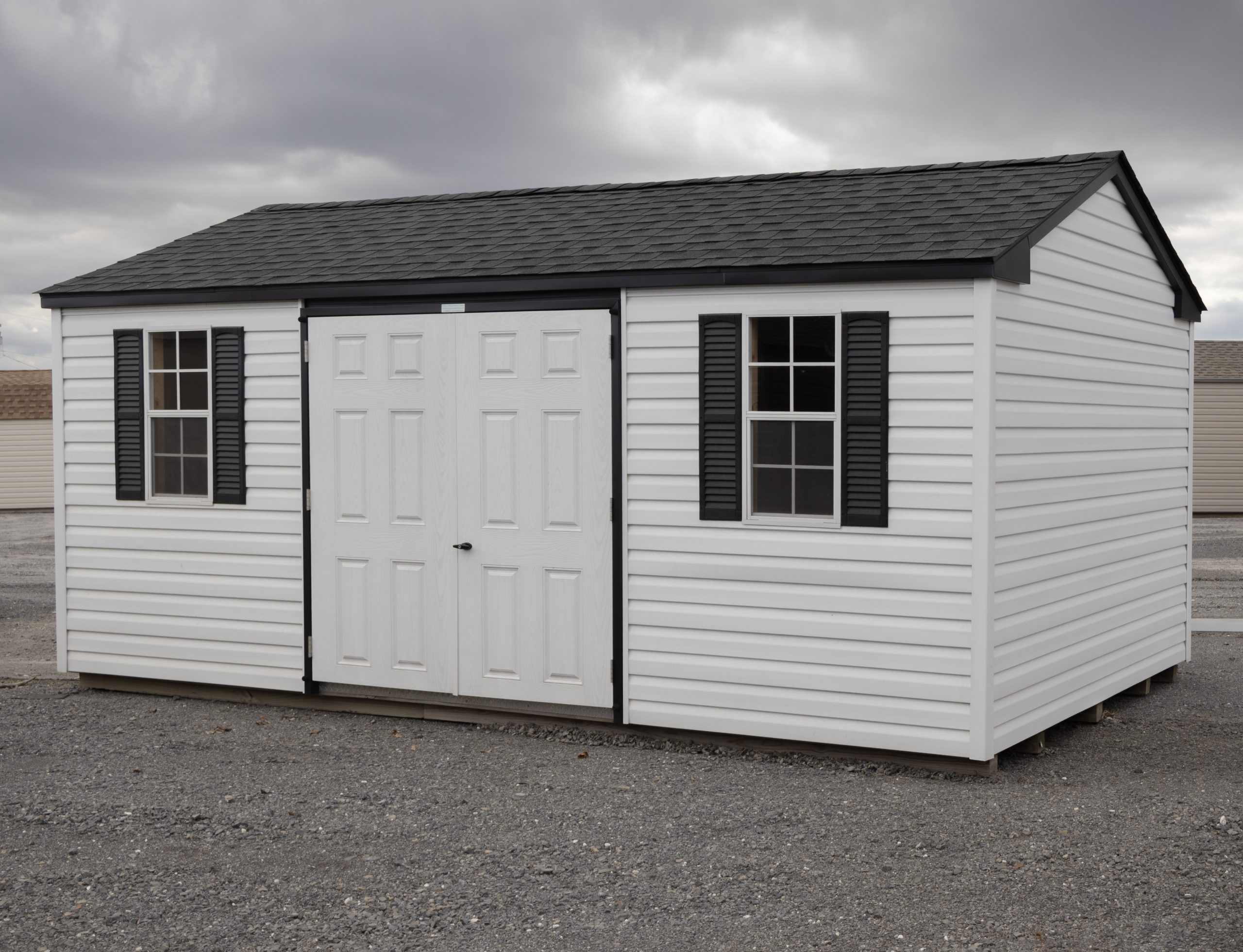 10x18 Peak Style Storage Shed with white vinyl siding and black accents