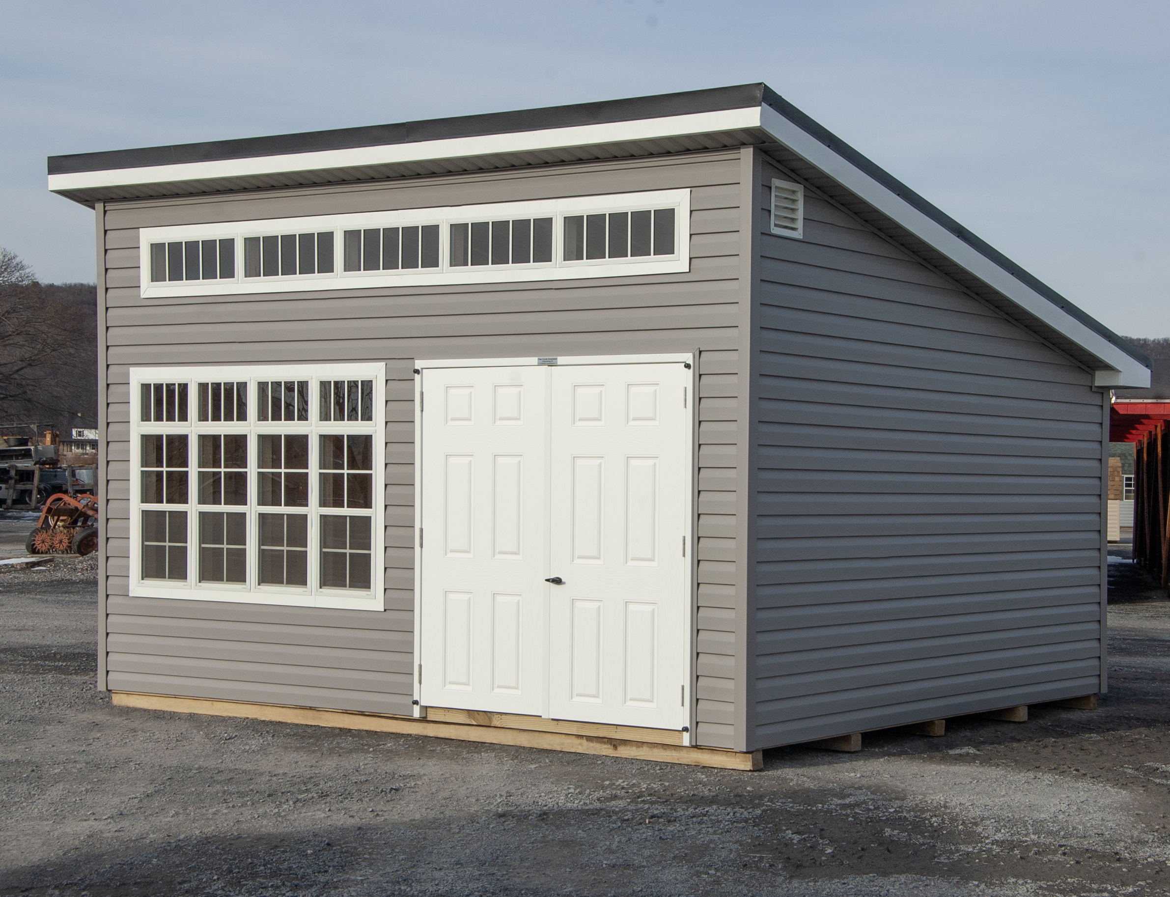 12x16 Studio Style Storage Shed with many windows and graphite grey vinyl siding