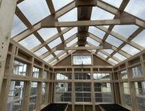 Double-wall polycarbonate atrium greenhouse roof with high tunnel vent for temperature control.