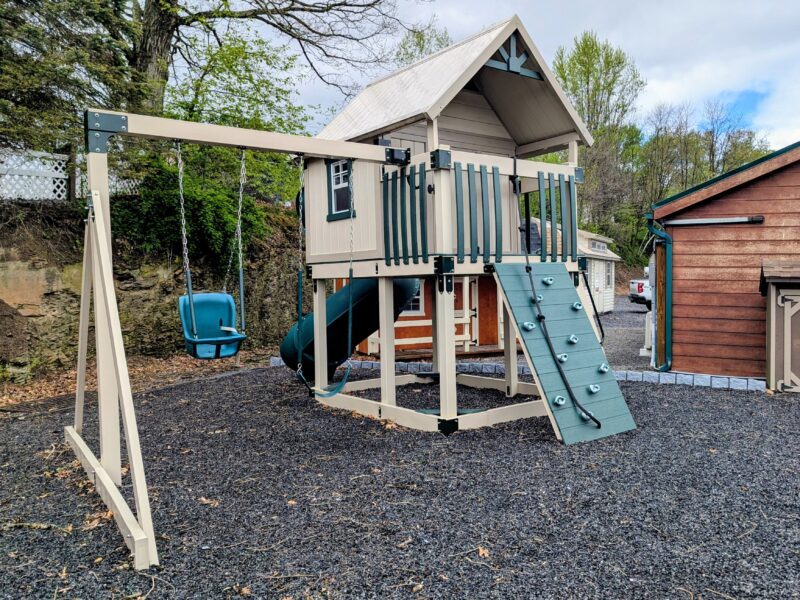 Vinyl swing set with clubhouse, climbing wall, rope, and tube slide on rubber mulch