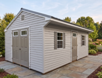 Exterior of a 12x20 Cottage Series shed with Harbor Stone vinyl siding, charcoal saltbox roof, and grey shutters.