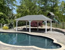 Custom Amish built 14x20 hip pavilion with white vinyl trim and black architectural shingles in a backyard patio setting.