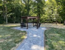 Wooden pergola and porch swing combo in a backyard setting