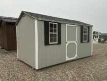 Side view of 8x14 grey storage shed showing the single entry door, double doors, and peak roof design.
