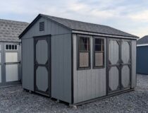 10x12 Economy Peak storage shed with double doors, side door, two windows, and shingle roof