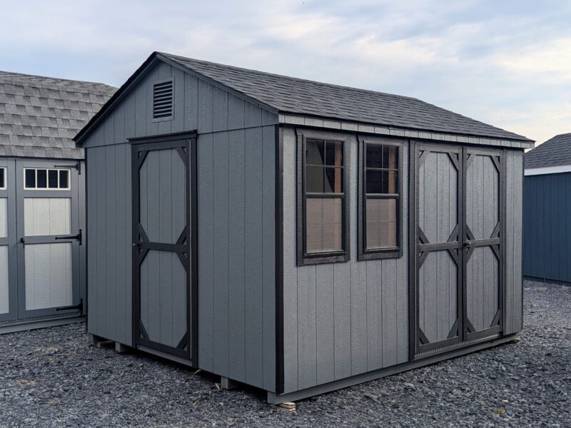 10x12 Economy Peak storage shed with double doors, side door, two windows, and shingle roof