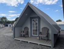 Front view of 12x20 A-frame cabin with covered porch and full-view entry door