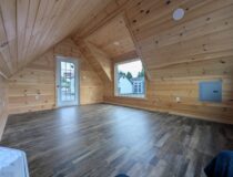 12x20 A-frame cabin interior with pine walls, picture window, electrical service, and entry door