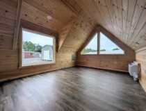 Finished 12x20 A-frame cabin interior with knotty pine walls and large windows