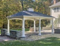 14x18 white vinyl hip roof pavilion installed over a backyard patio by Pine Creek Structures