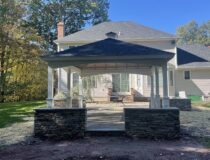 Side angle of a 14x18 vinyl pavilion with charcoal shingles and a custom cupola