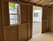 Interior view showing the single-hung window and open layout of the 10x14 Madison Peak storage shed.