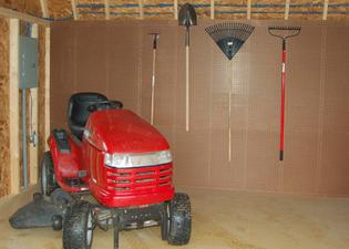 Storing a riding lawn mower and other lawn care tools inside a shed