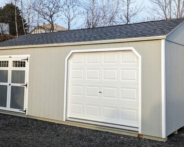 12x24 Peak Storage Shed. Light grey LP SmartSiding siding with white trim. Garage door and double door on a 24' side